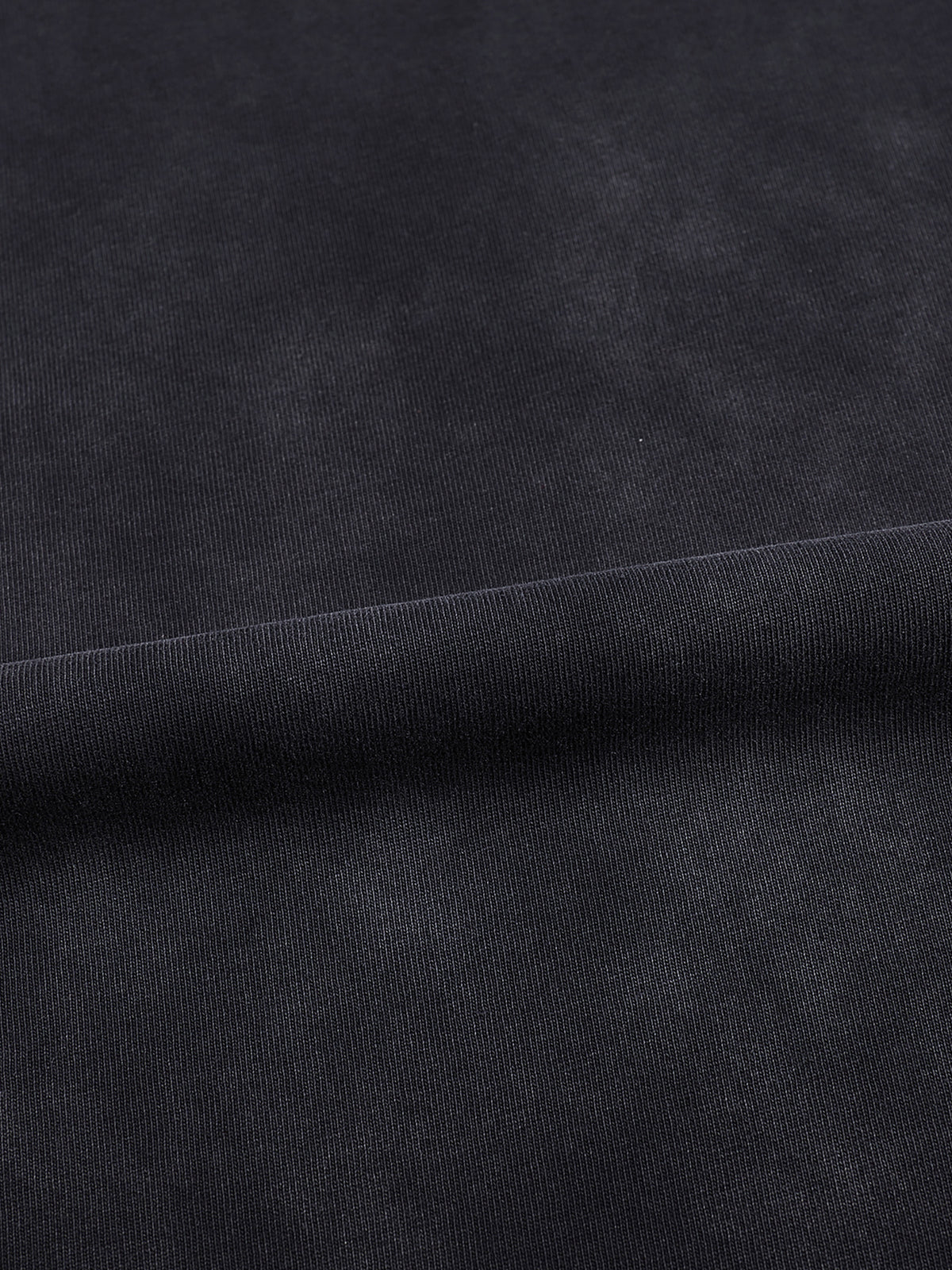 Macro detail of the vintage black-gray washed 100% cotton fabric used in the Meme Boutique tee